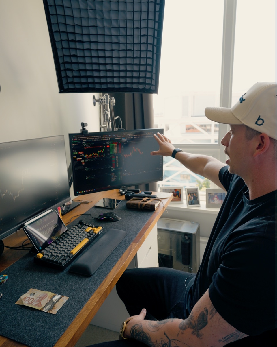 Trader Mayne pointing at a chart on his trading desk